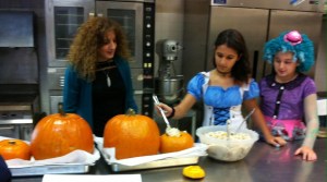 Students help fill the hollow pumpkins before baking 